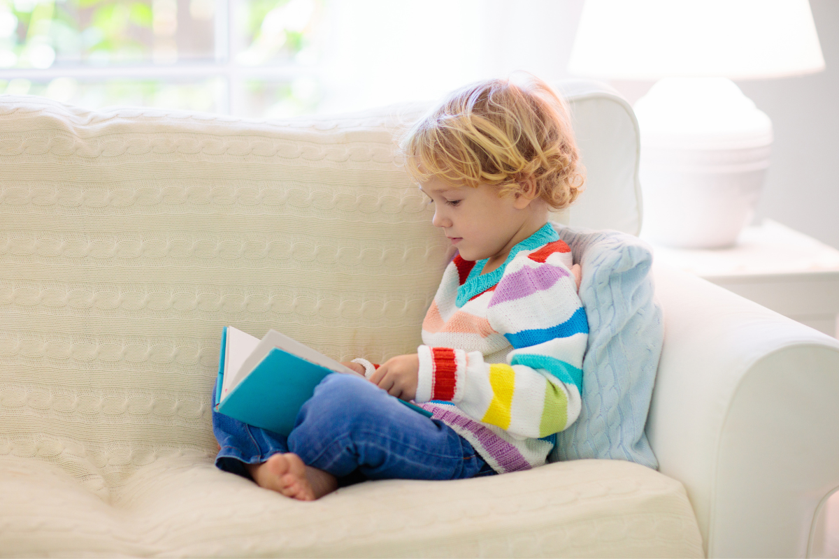 Child Reading While Sitting On Couch