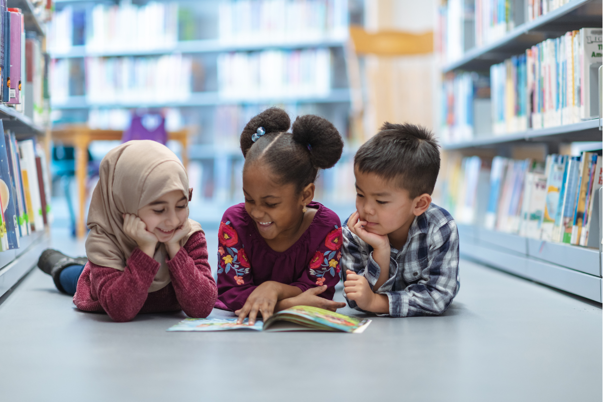Children Reading On Floor Of Library